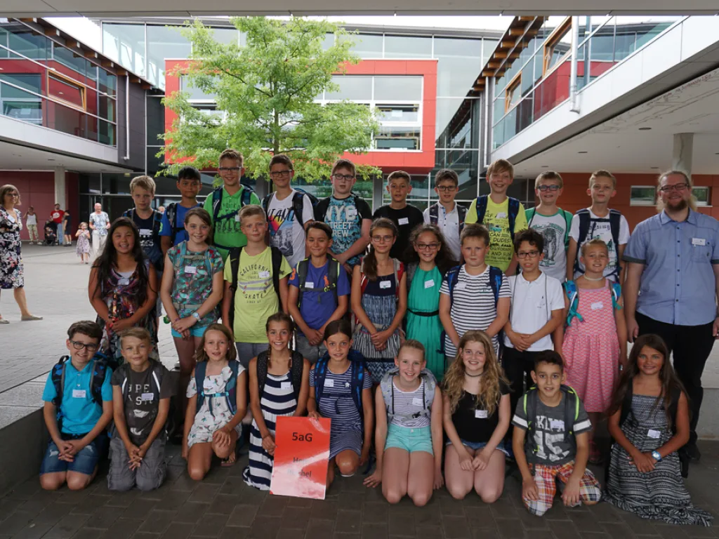 Klassenfoto einer neuen fünften Klasse mit rotem Schild.